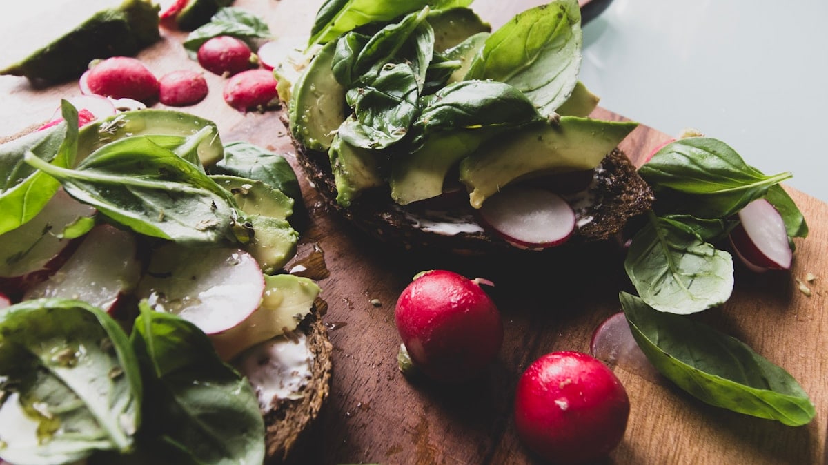 sliced cucumber and red tomato on brown wooden chopping board