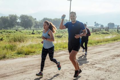 A group of runners enjoys a vibrant morning jog on a rural dirt road.