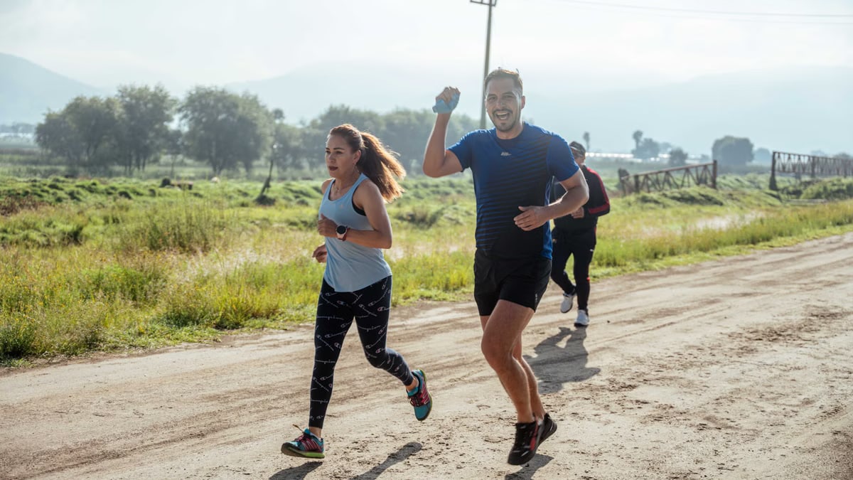 A group of runners enjoys a vibrant morning jog on a rural dirt road.